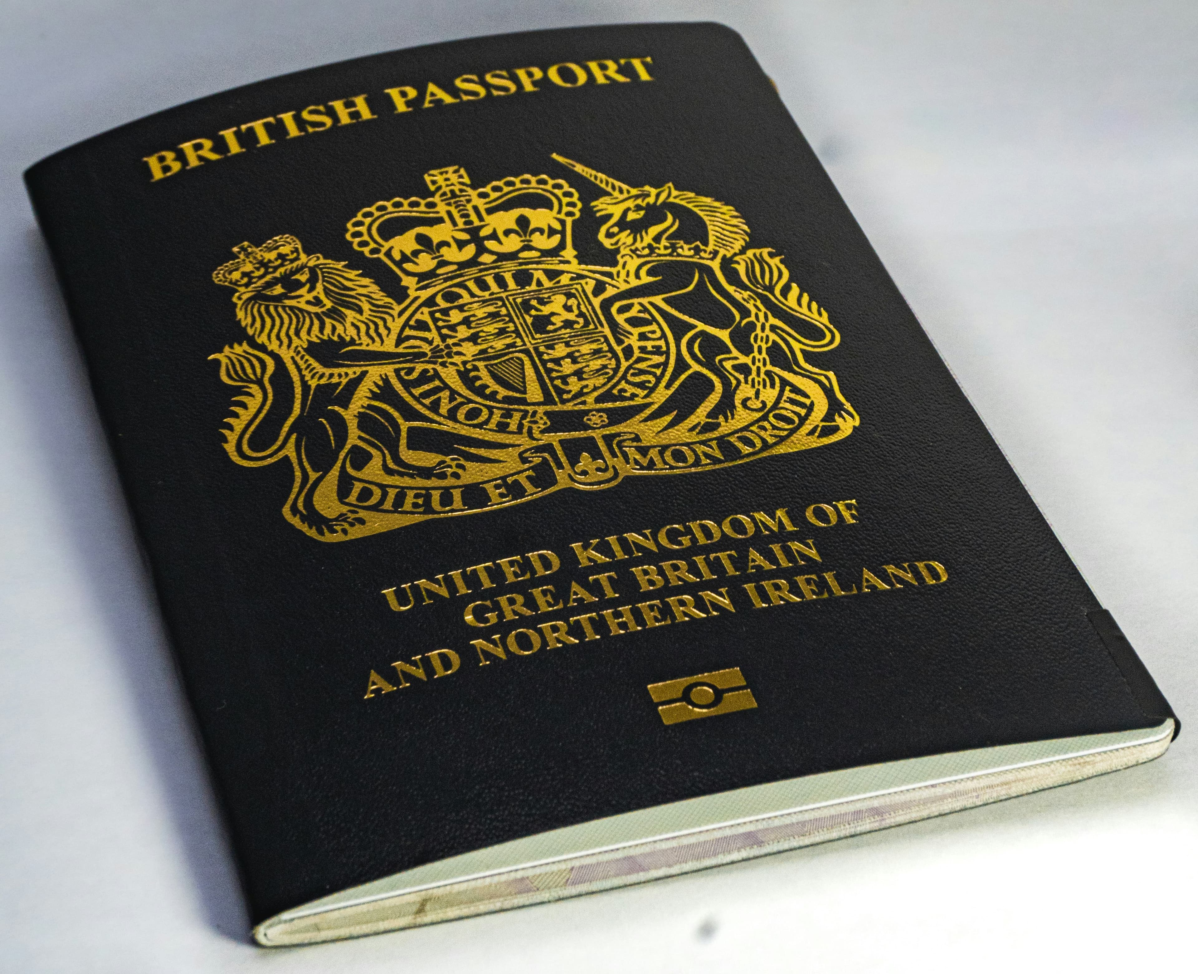 Black and gold passport on white table representing identity document security and protection